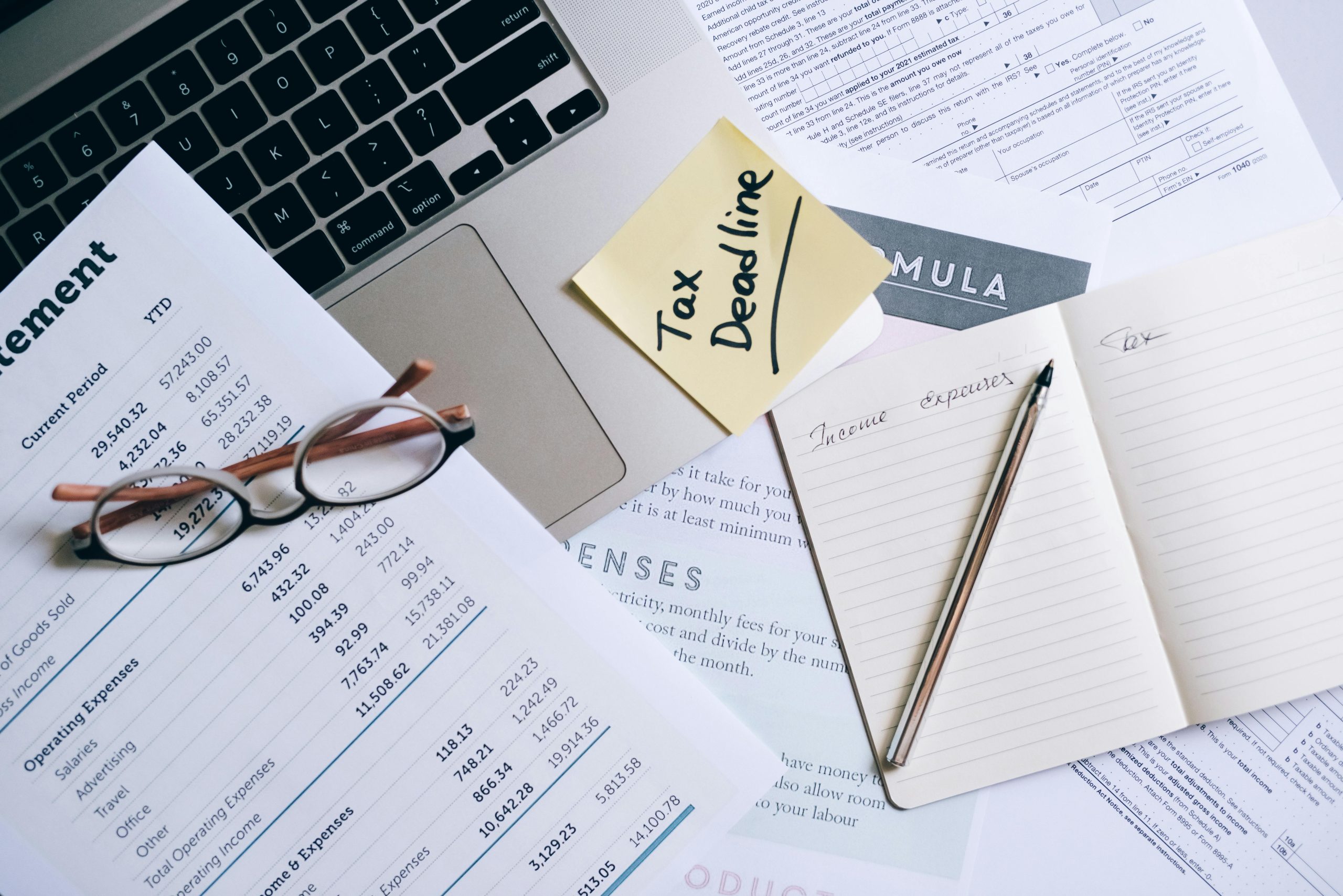 Checklist with reading glasses, sticky note, and note pad