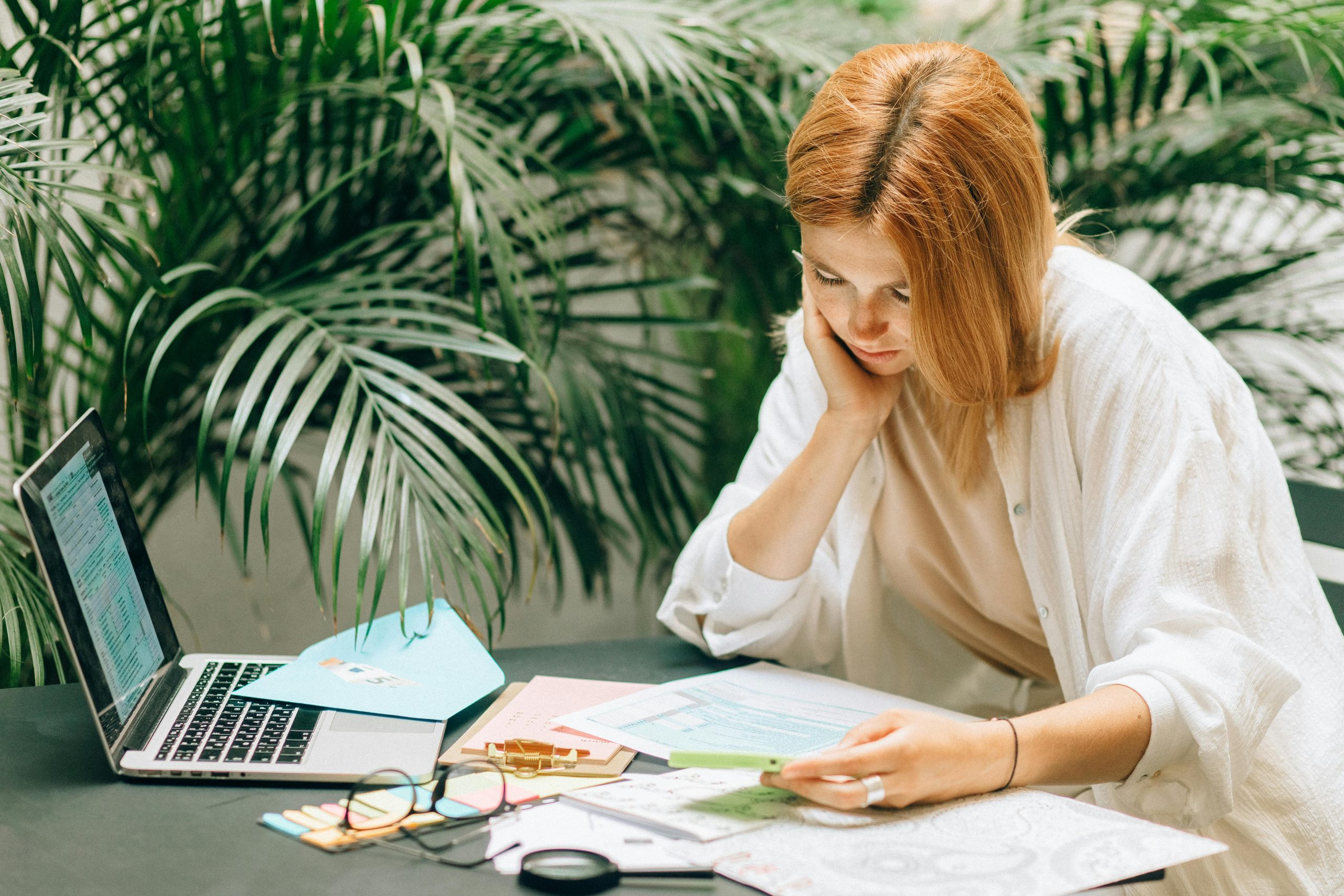 Creative professional at desk with laptop and calendar, working on financial planning for creatives