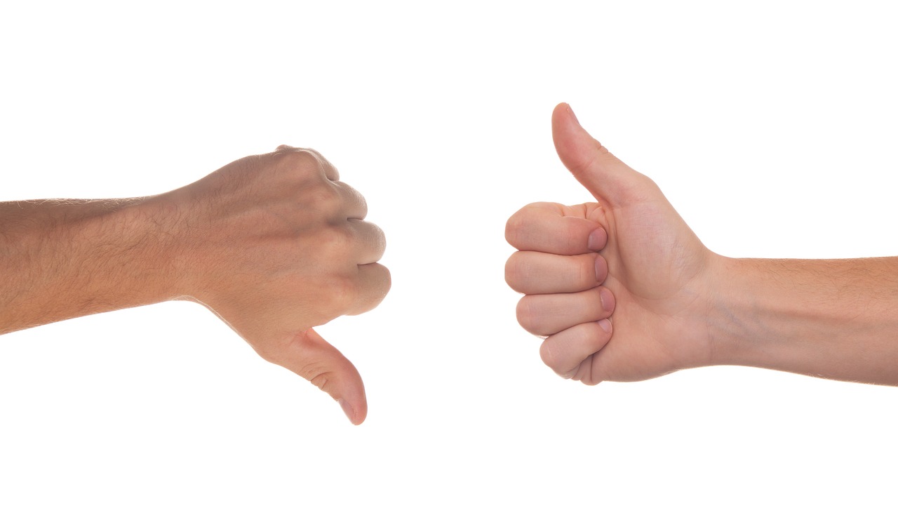 Two hands giving thumbs up and thumbs down, representing client fit decisions for creative freelancers.