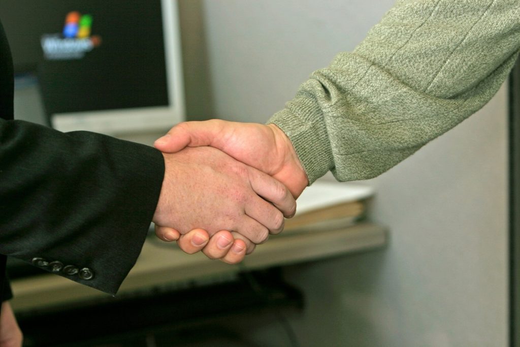 a professional and client shaking hands after agreeing on project payment terms
