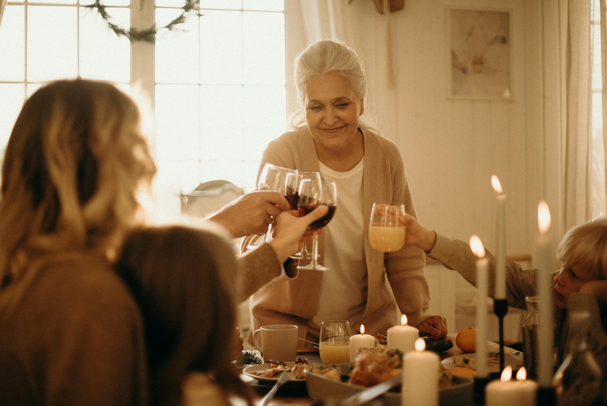 Family gathered at a holiday dinner table raising glasses in a warm toast that reflects gratitude in business and daily life.